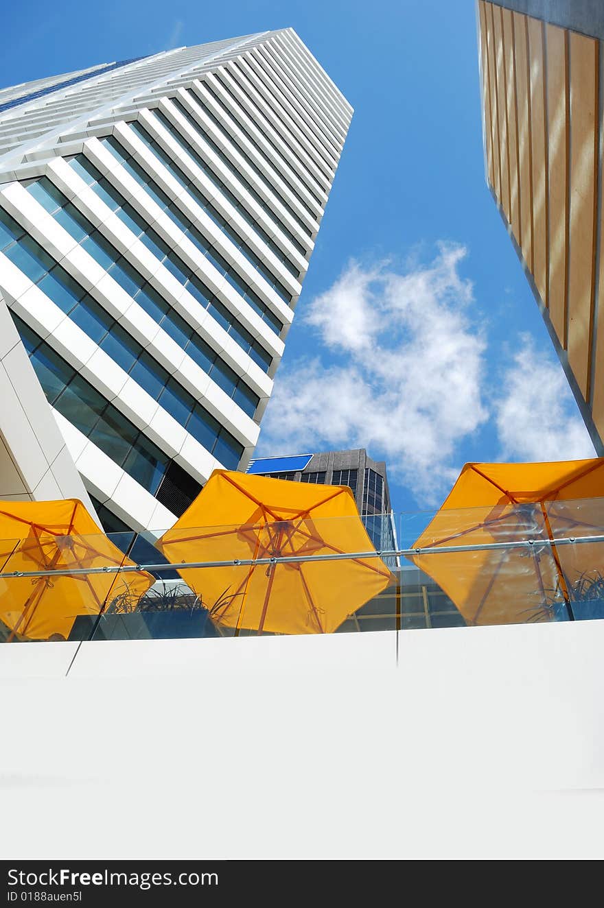 Modern building on a background of blue sky and yellow umbrella