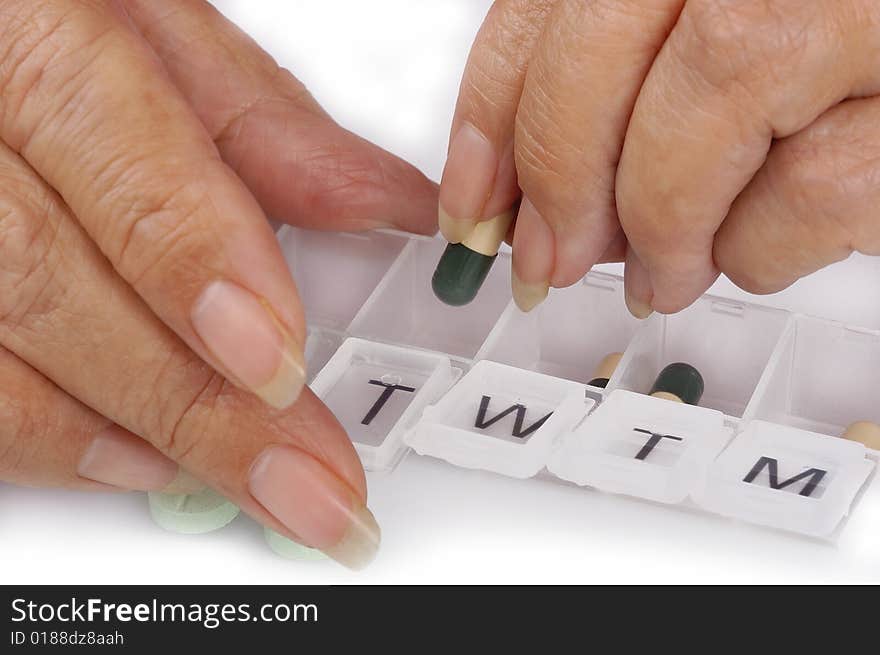 Sorting capsules into a weekly pill dispenser. Sorting capsules into a weekly pill dispenser