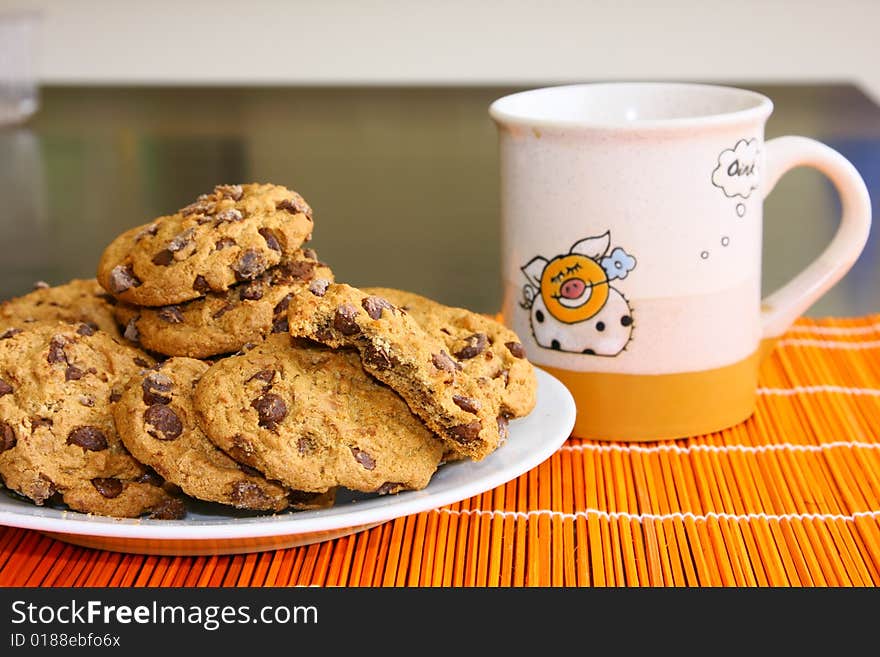 A few cookies on the plate and mug with cofee. A few cookies on the plate and mug with cofee