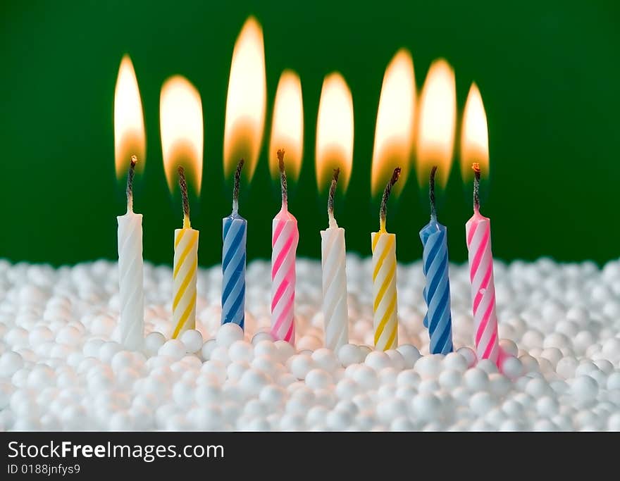 Beautiful colored candles over a green background. Beautiful colored candles over a green background