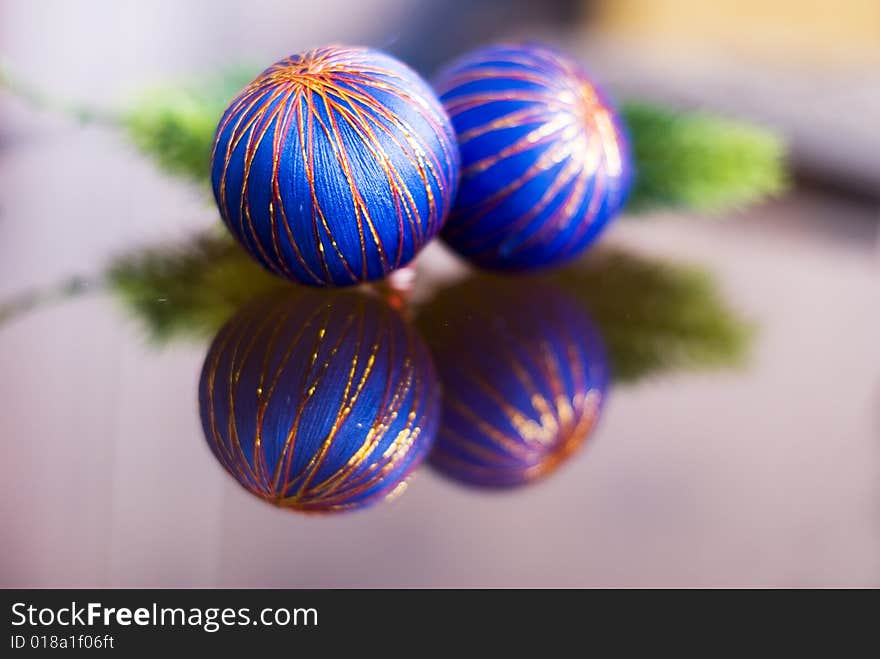 Two blue christmas balls with their reflection