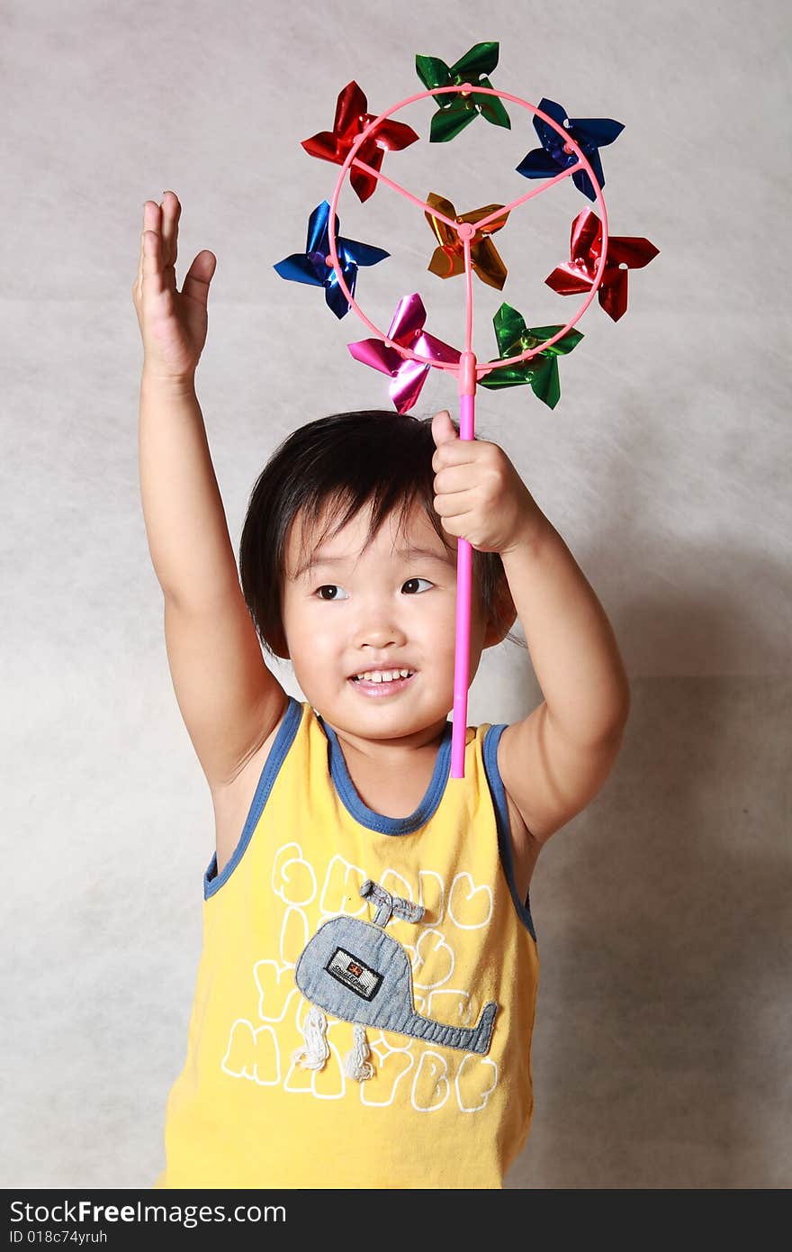 Young girl with toy windmill smiling at camera. Young girl with toy windmill smiling at camera