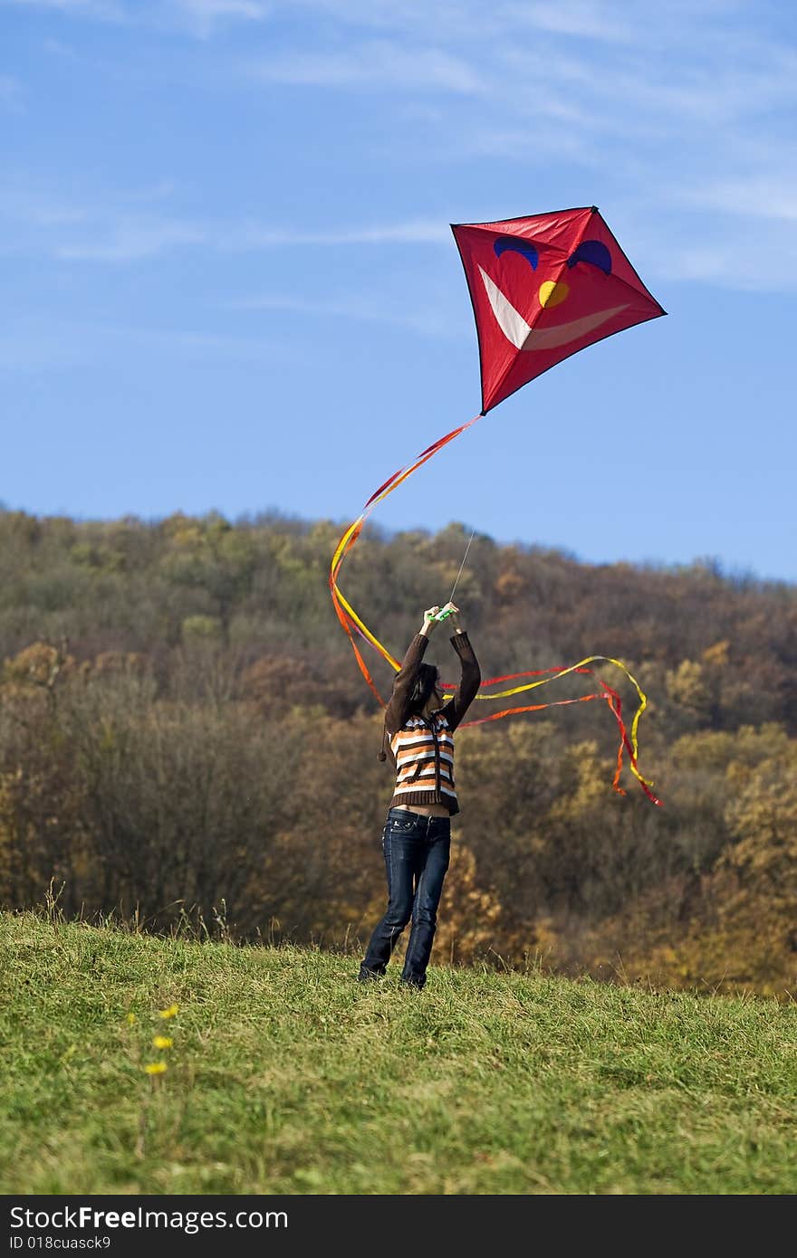 Fly a kite, teenager in fall weather in nature