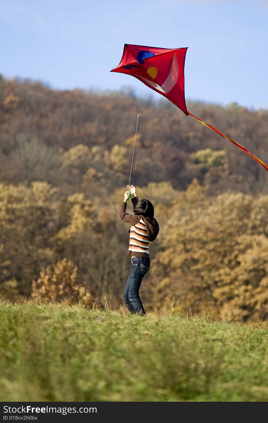 Fly a kite, teenager in fall weather in nature