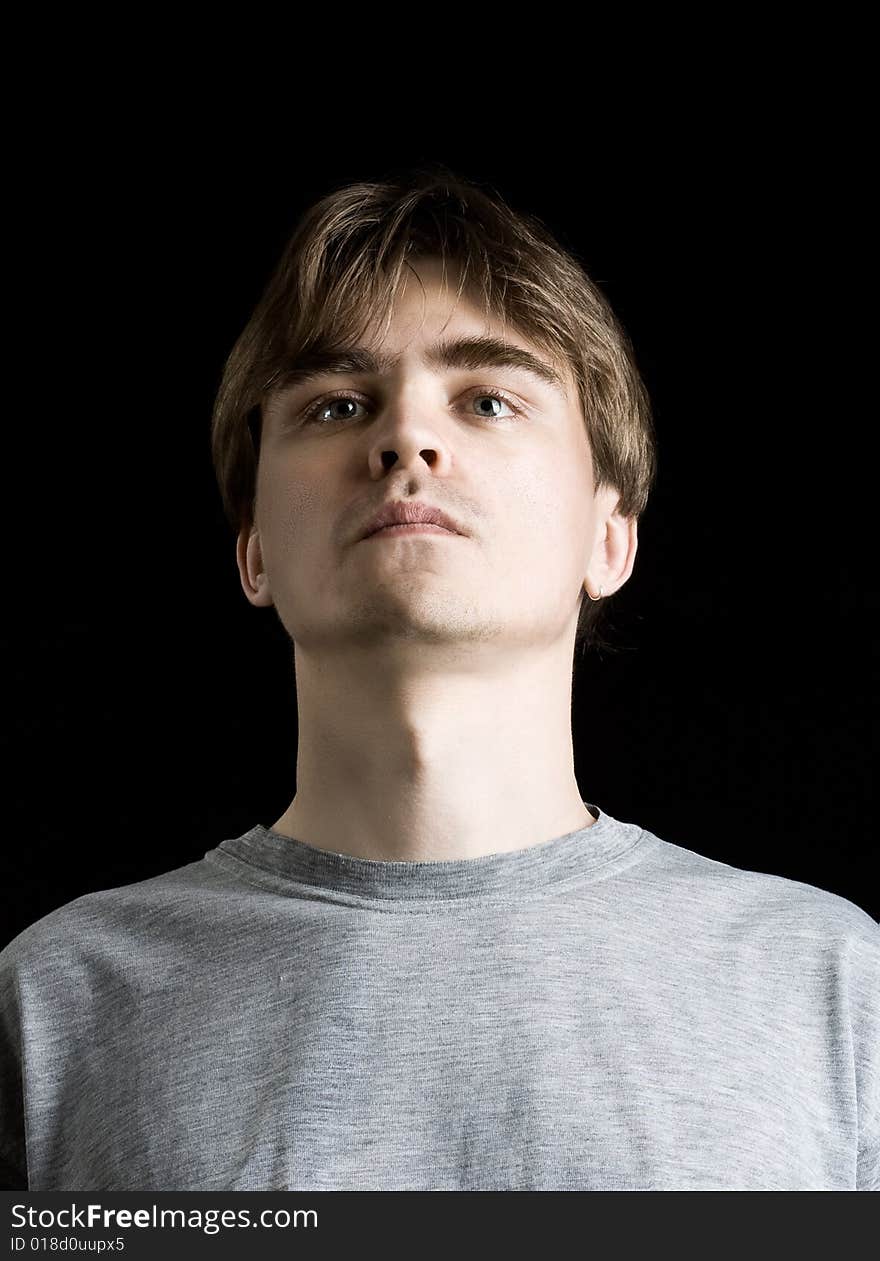 Close up portrait of young man on black background