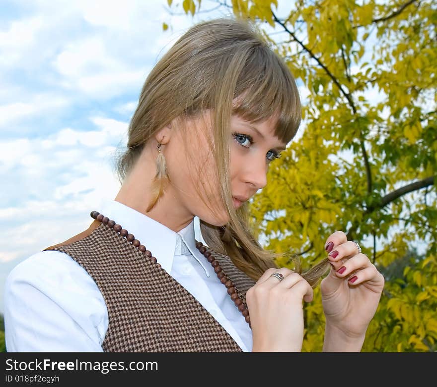 Portrait of the beautiful young girl against green foliage