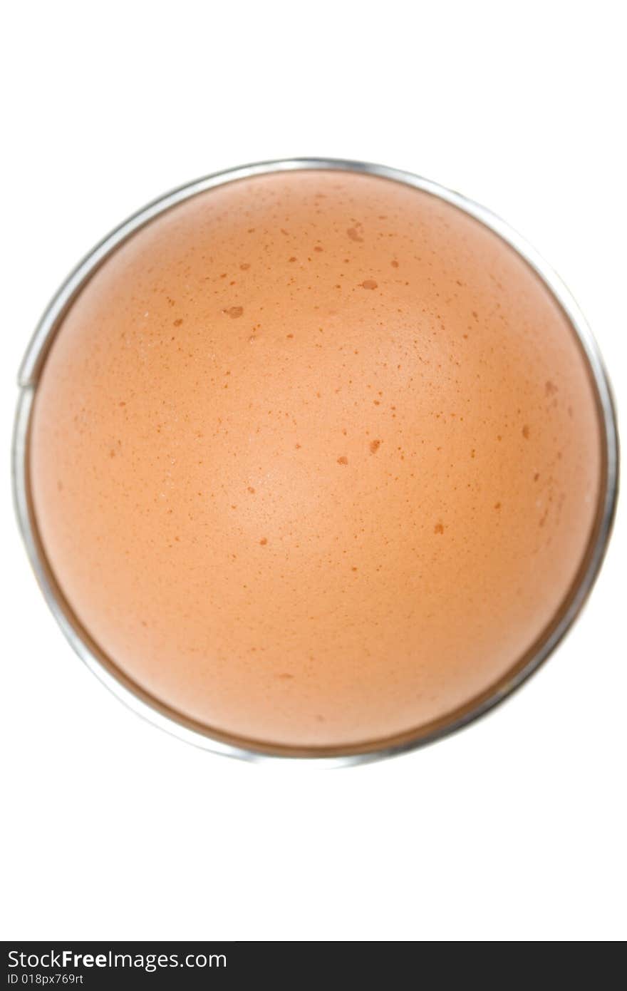 Brown egg in an eggcup on white background