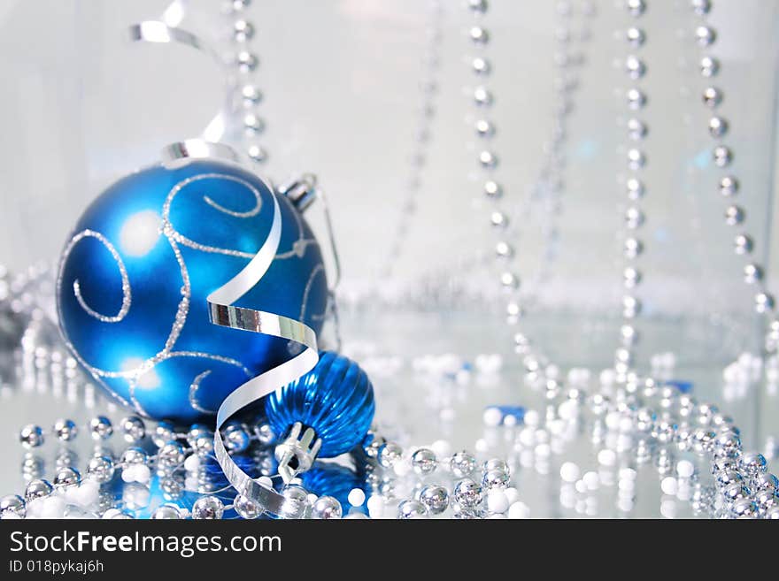 A lovely blue baubles on a mirror  surface with ribbons and beads. A lovely blue baubles on a mirror  surface with ribbons and beads.