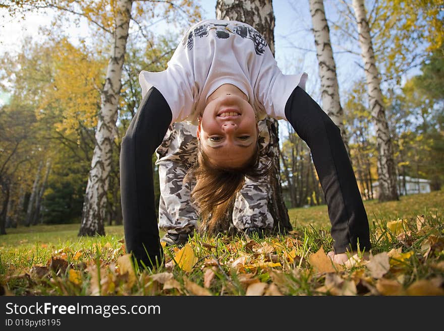 A young woman makes a handstand