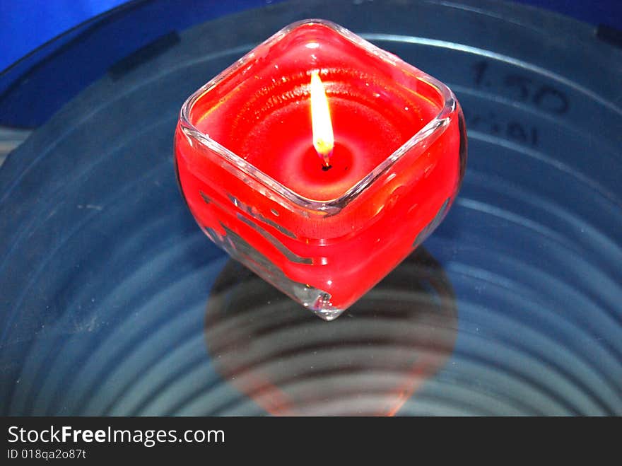 A candle with blue metalic background