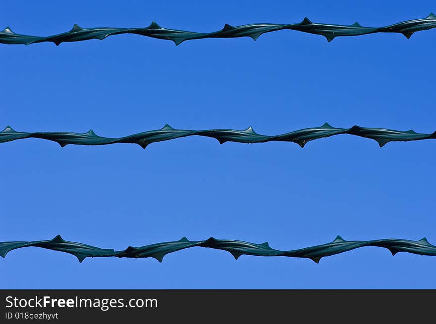 A modern barbed wire on a blue sky. A modern barbed wire on a blue sky