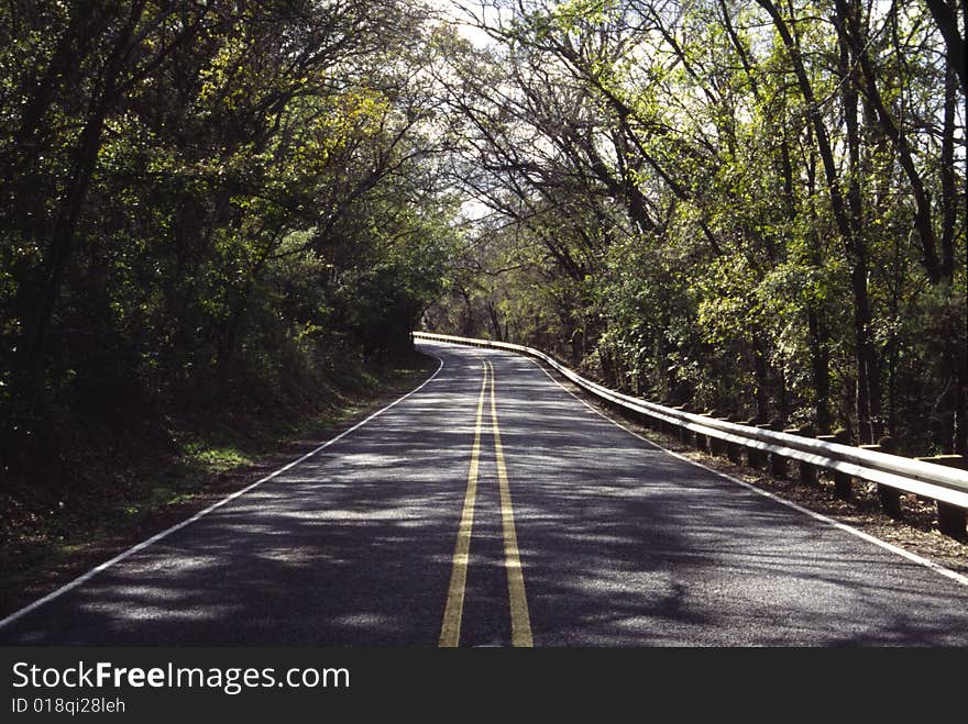 A lonely back road through a forest area. A lonely back road through a forest area.