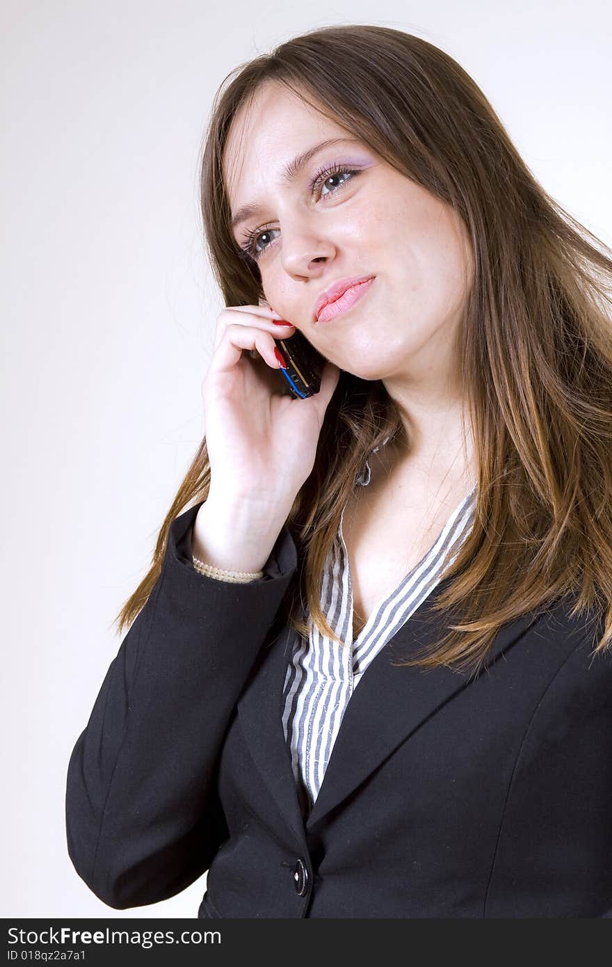 Beautiful girl talking over a cellphone, smiling sensually. Beautiful girl talking over a cellphone, smiling sensually