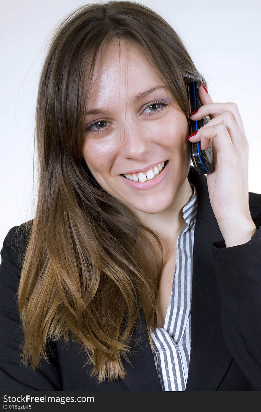 Pretty girl, listening over a cellphone, looking very happy, showing a big smile. Pretty girl, listening over a cellphone, looking very happy, showing a big smile