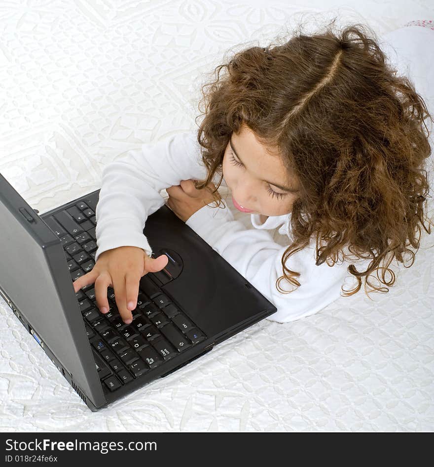 Young girl with a laptop computer on the bed. Young girl with a laptop computer on the bed