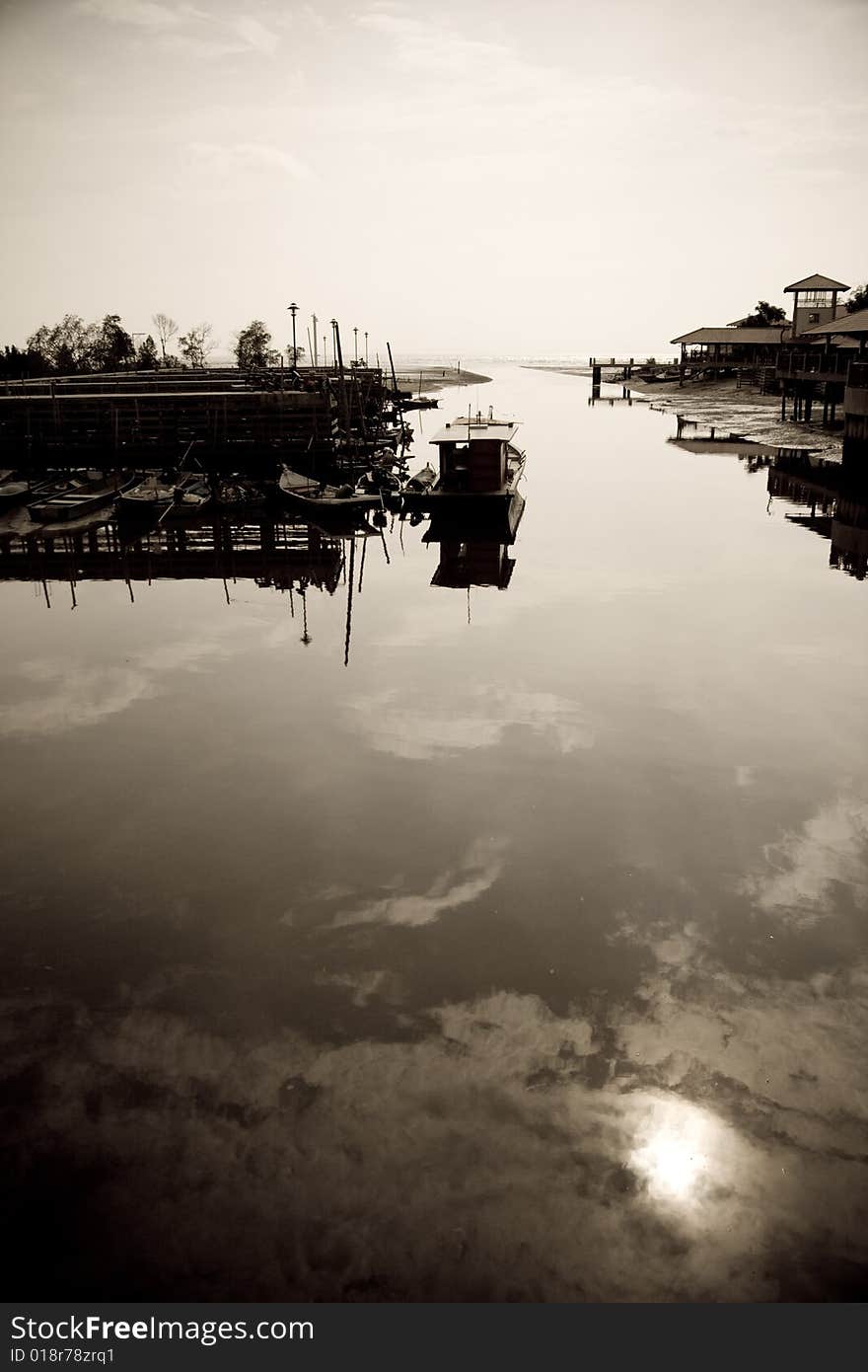 An afternoon shot of a fishing jetty where the water is calm as fishermen are resting after a hard day of work. An afternoon shot of a fishing jetty where the water is calm as fishermen are resting after a hard day of work.