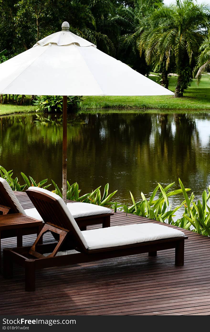 Deck chairs and umbrellas next to a lake. Deck chairs and umbrellas next to a lake.