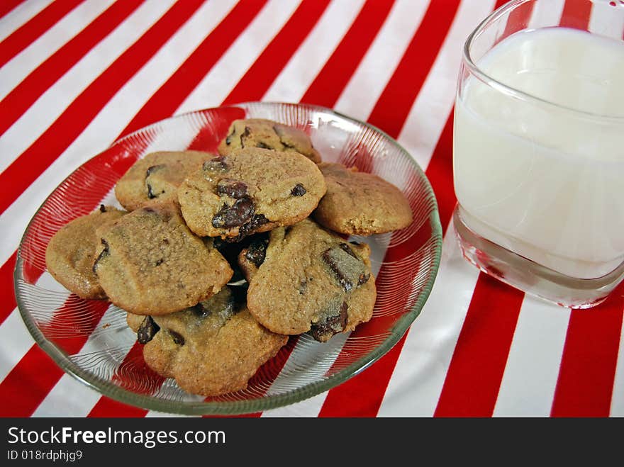 Plate of cookies with milk on festive stripes. Plate of cookies with milk on festive stripes.