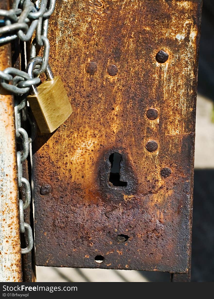 Rusted keyhole with padlock and chain