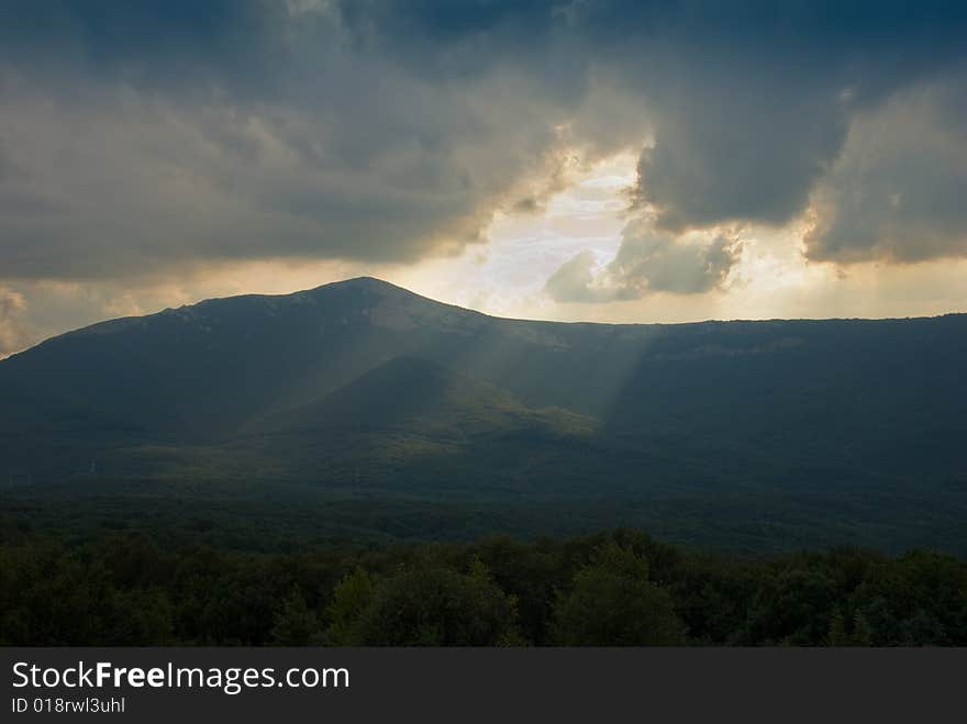 Sunbeams through the cloudy sky in mountains