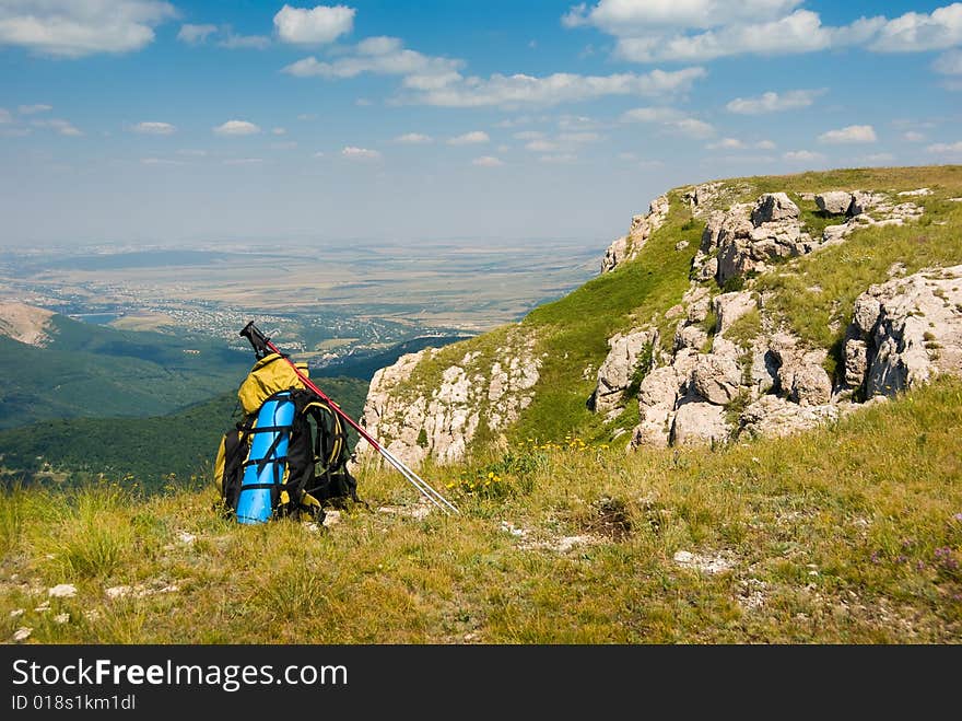 Summer mountain landscape with backpack in foreground. Summer mountain landscape with backpack in foreground