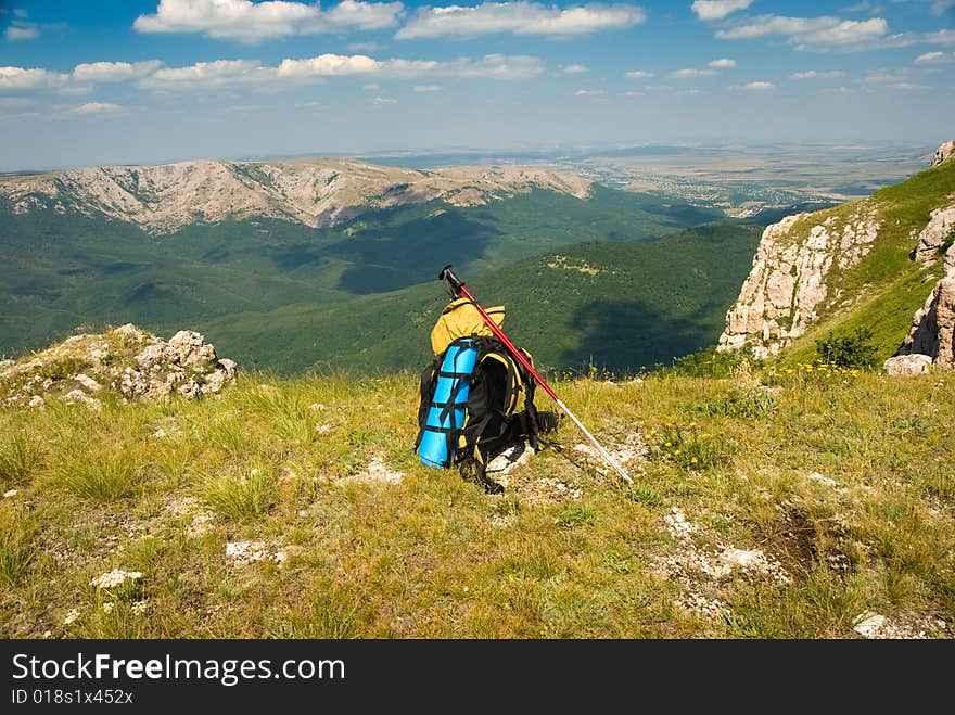 Summer mountain landscape with backpack in foreground. Summer mountain landscape with backpack in foreground