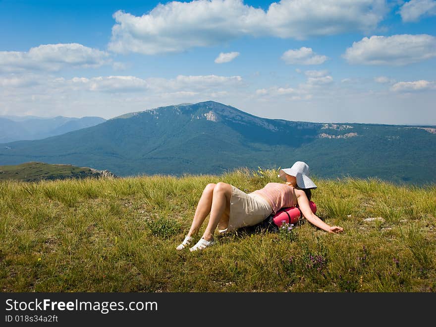 Happy all-in hiker relaxes on the grass in mountains. Happy all-in hiker relaxes on the grass in mountains