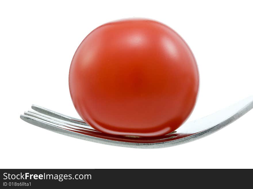 Cherry tomato and fork on white. Cherry tomato and fork on white.