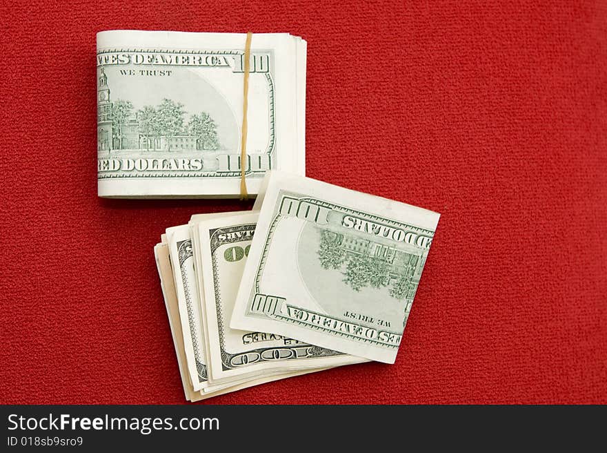 Stack of $100 bills on red background