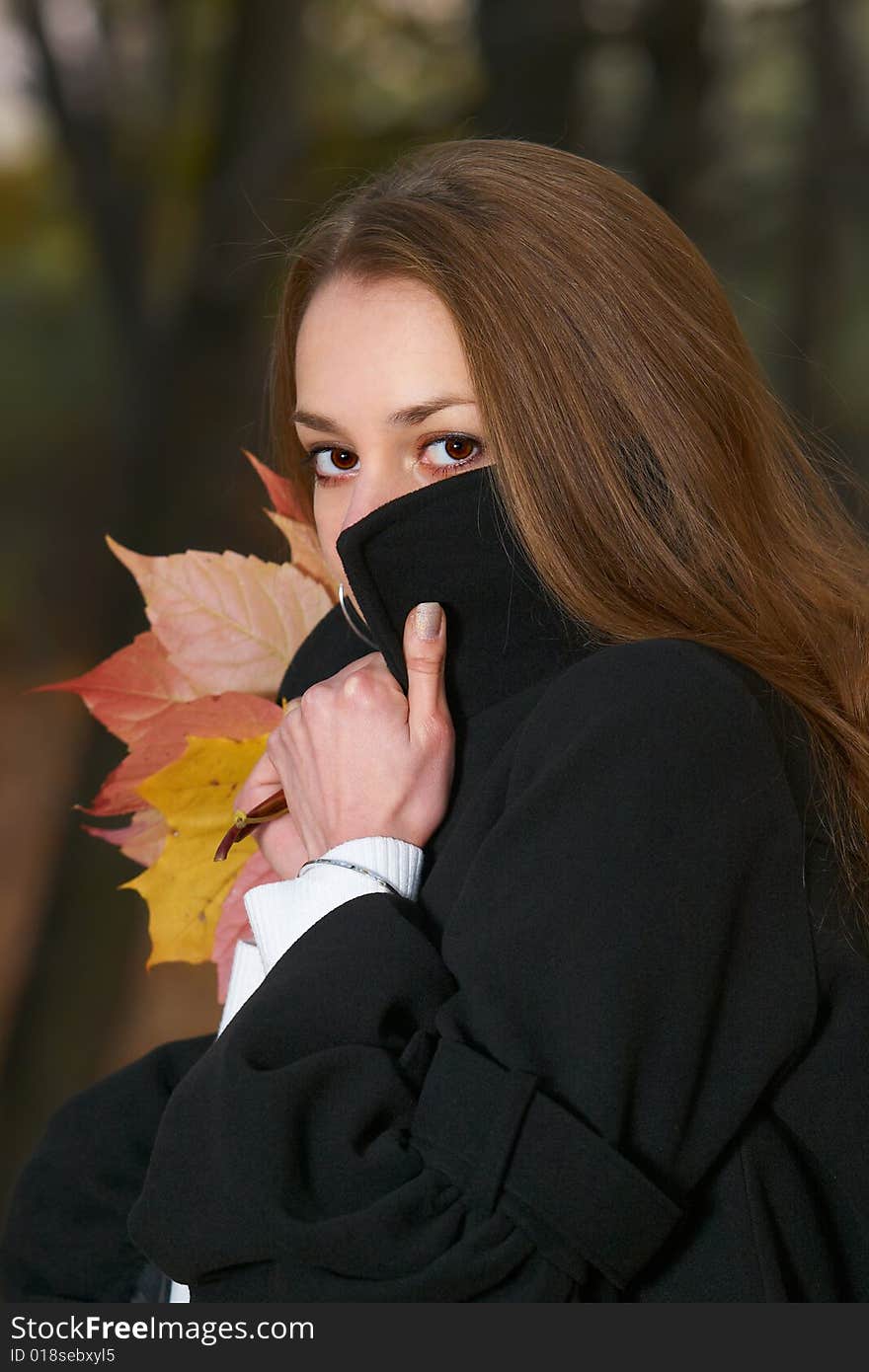 Young girl hides behind stand-up collar.