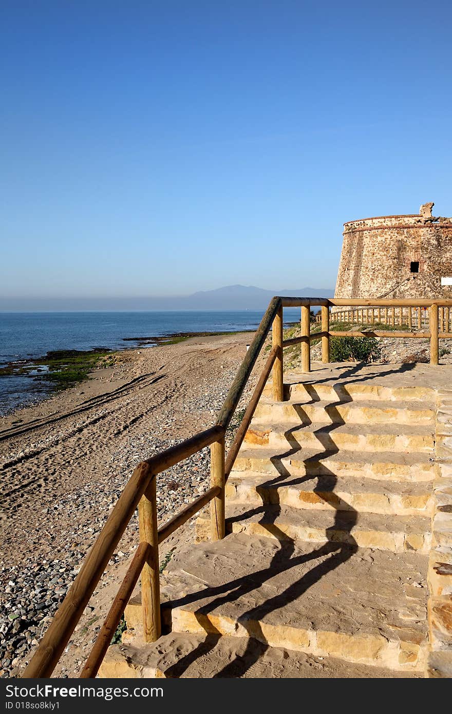 Ancient Moorish Tower beach and steps down to sea at Marbella in Southern Spain. Ancient Moorish Tower beach and steps down to sea at Marbella in Southern Spain