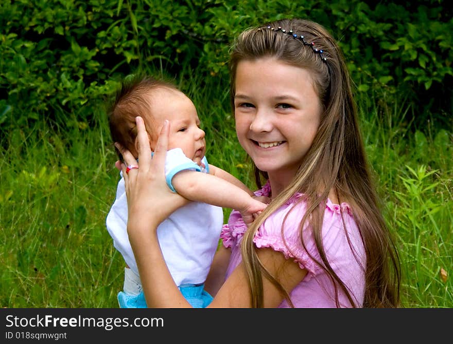 Happy little girl holding her baby brother. Happy little girl holding her baby brother