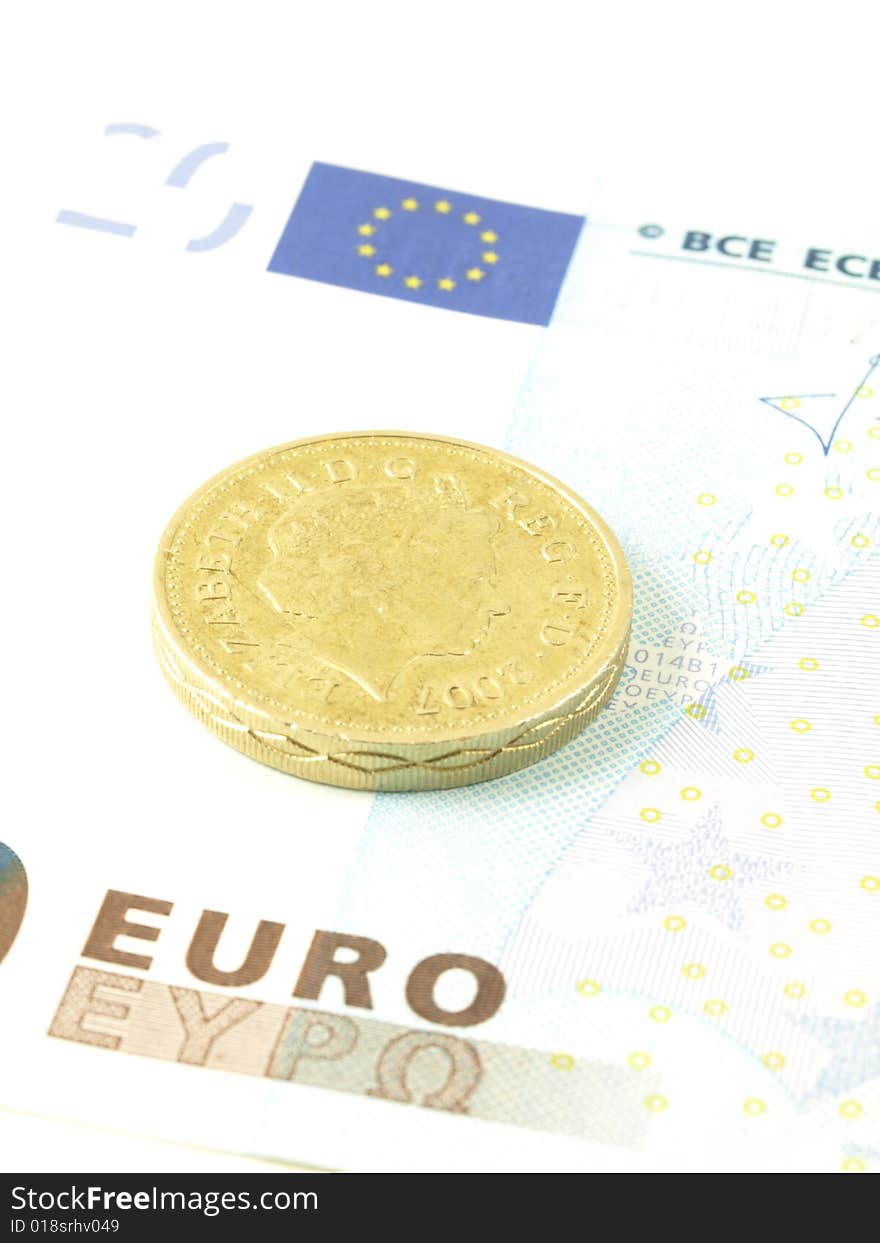 Close-up of a pound coin on twenty euro banknote. Close-up of a pound coin on twenty euro banknote.