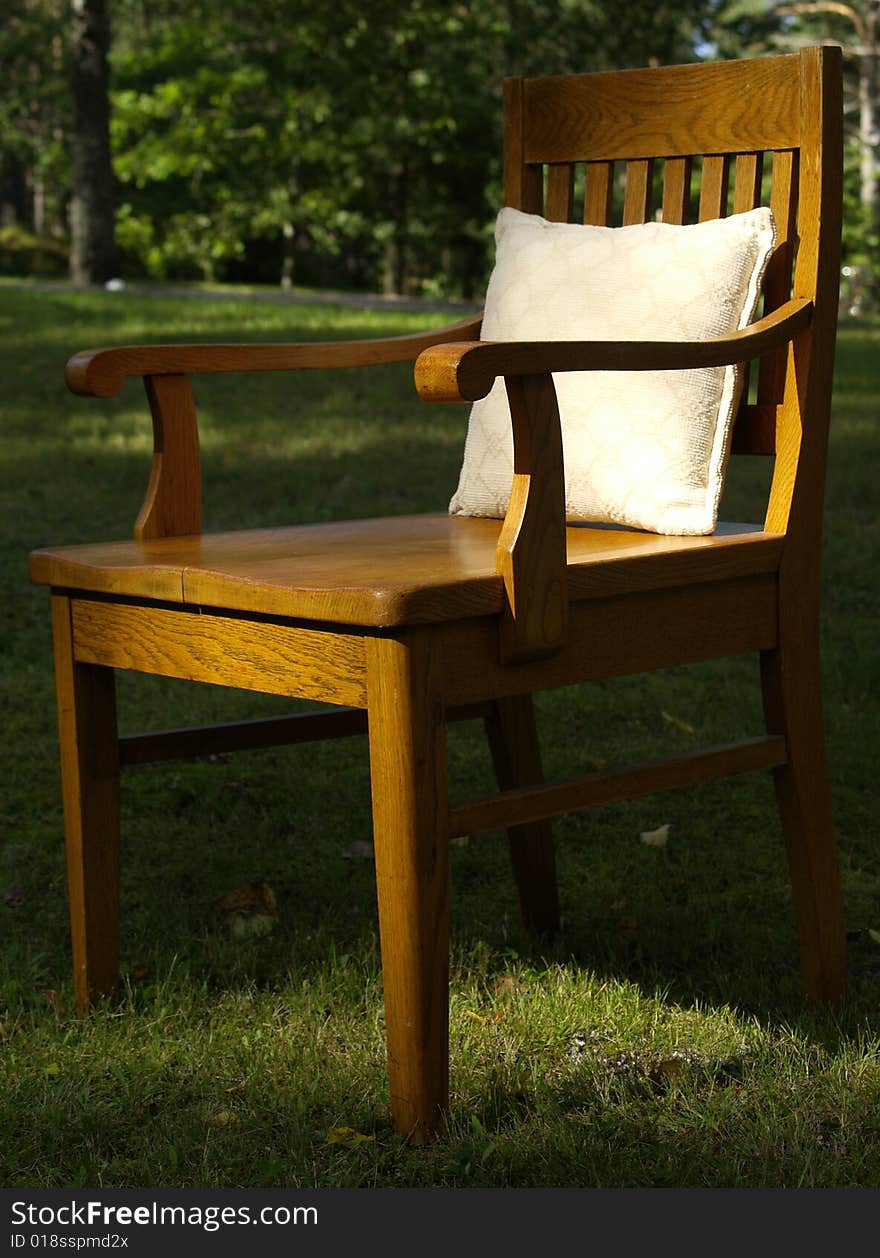 Old wood chair on the grass with pillow. Old wood chair on the grass with pillow