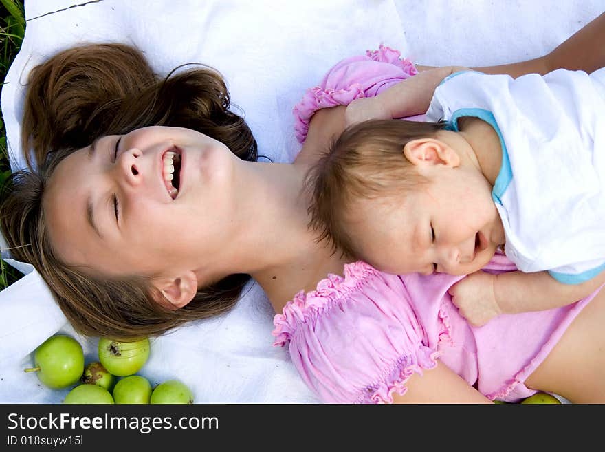 Little girl and her baby brother lying among apples. Little girl and her baby brother lying among apples