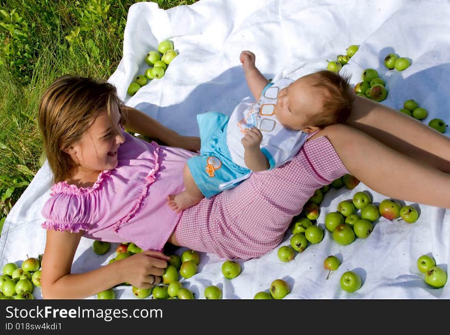 Little girl and her baby brother lying among apples. Little girl and her baby brother lying among apples