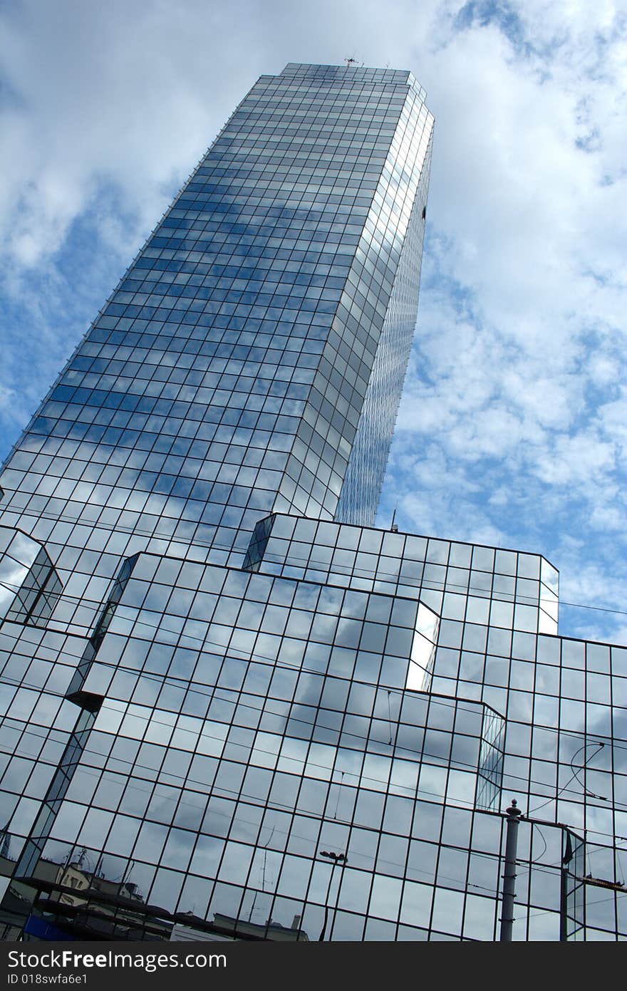 Silver skyscraper with sky reflecting in windows.