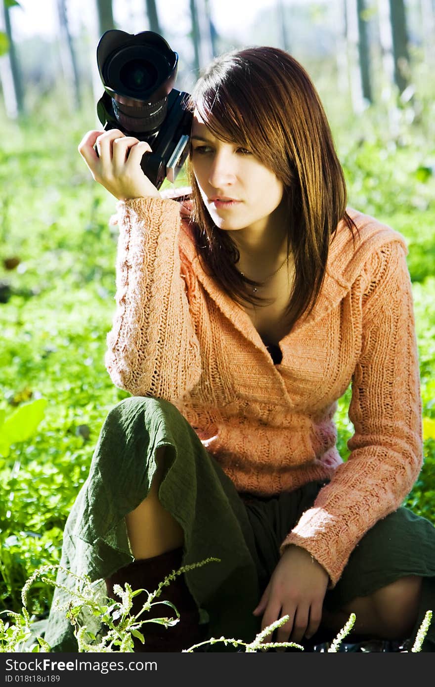 Young pretty female photographer in a forest.