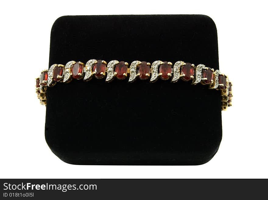 Garnet and diamond gold bracelet set on a black velvet box