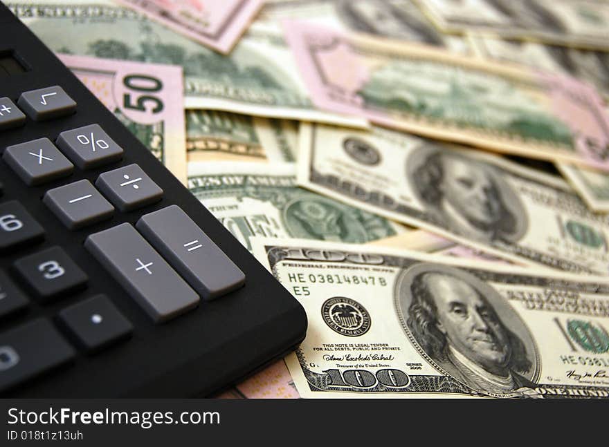 Calculator on cash money background of $100 and $50 banknotes. Calculator on cash money background of $100 and $50 banknotes