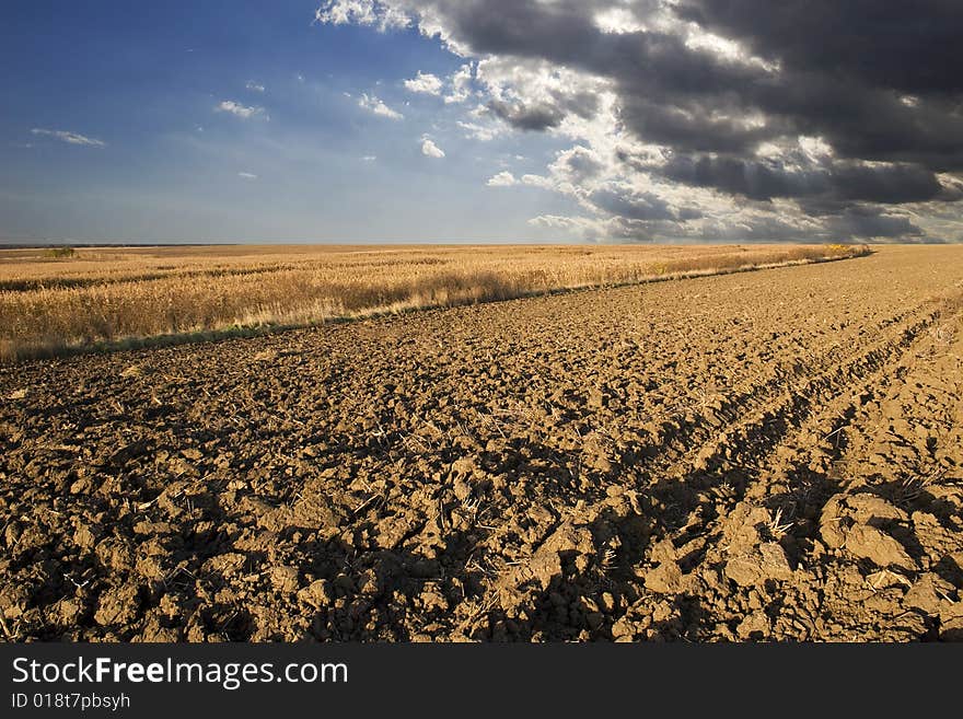 Cultivated ploughland  and stormy clouds in background. Cultivated ploughland  and stormy clouds in background.