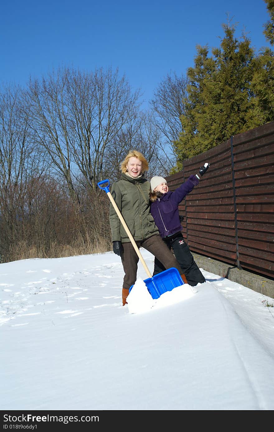 Mother and her daughter throw up snow on a winter background. Mother and her daughter throw up snow on a winter background