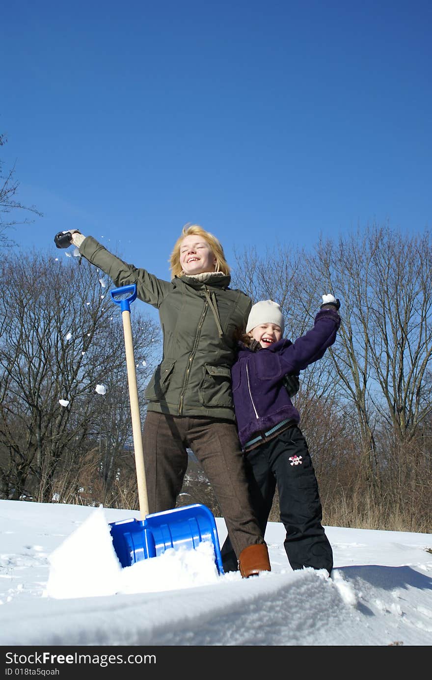 Mother and her daughter throw up snow on a winter background. Mother and her daughter throw up snow on a winter background