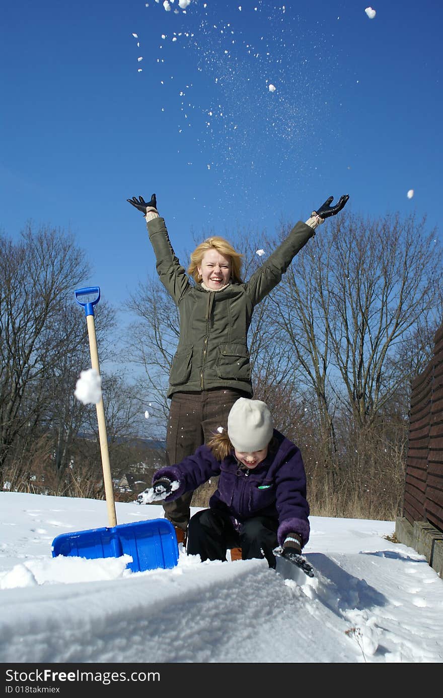 Mother and her daughter throw up snow on a winter background. Mother and her daughter throw up snow on a winter background