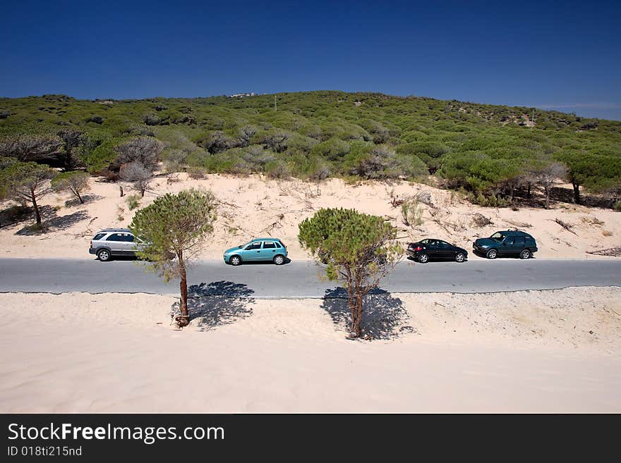 Cars parked on bright sunny sand dunes at Tarifa beach in Spain. Cars parked on bright sunny sand dunes at Tarifa beach in Spain