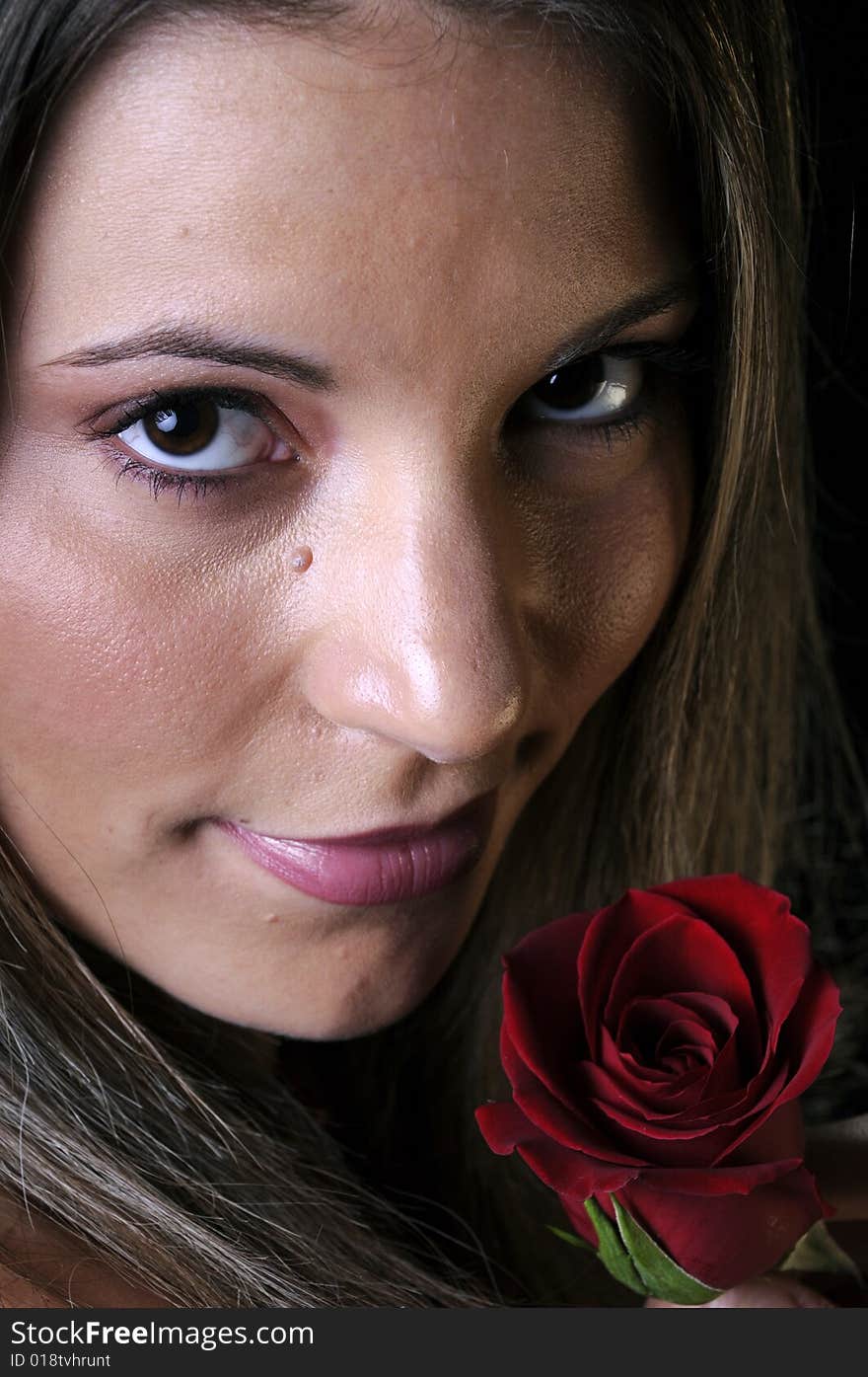 Beautiful young brunette woman holding a red rose for valentines. Beautiful young brunette woman holding a red rose for valentines