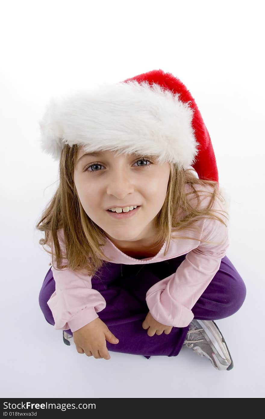 Sweet girl with christmas hat looking you against white background