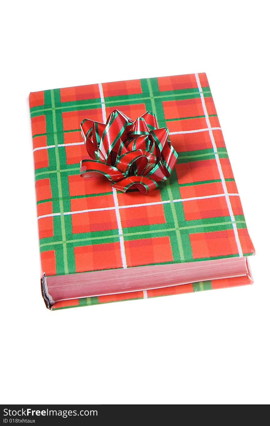 Book wrapped in traditional Christmas colors with red and green bow on top. Book wrapped in traditional Christmas colors with red and green bow on top