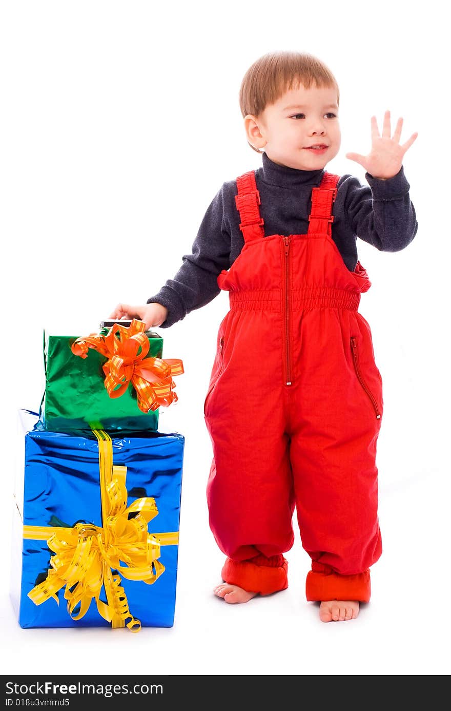 Cute two year old boy with a lot of presents waiving his hand