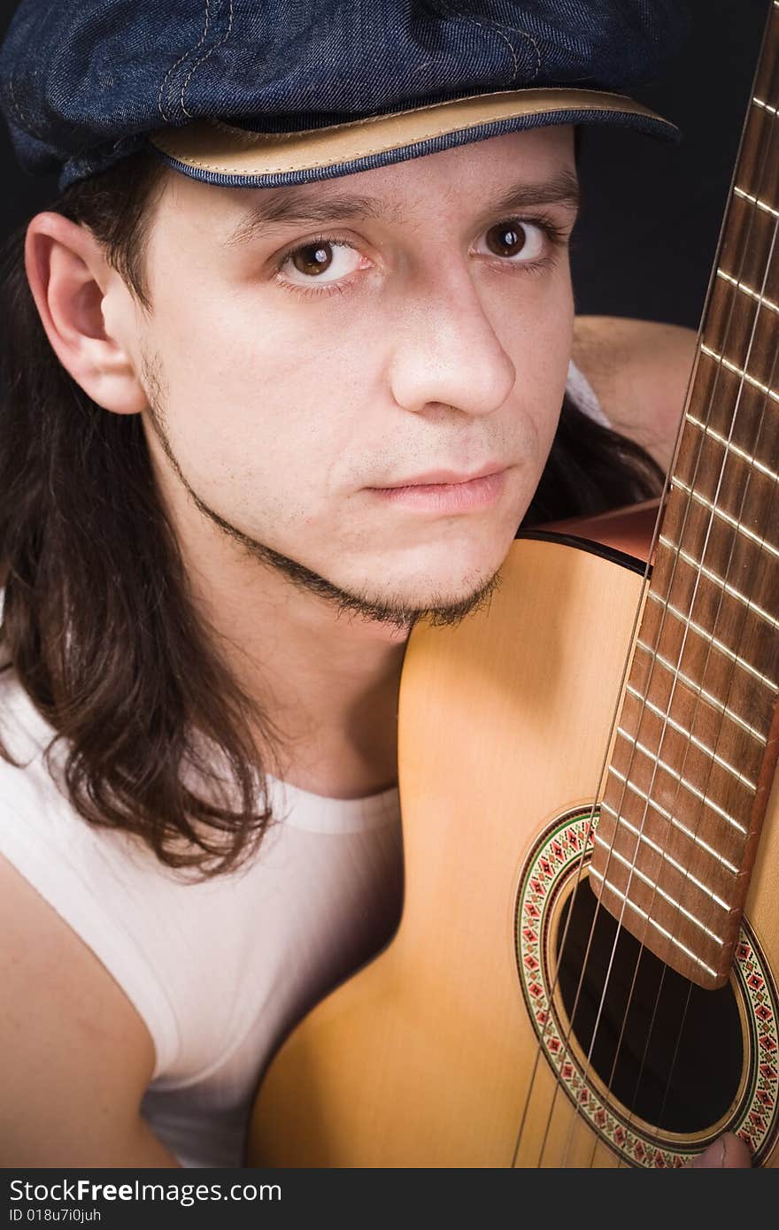 Cheerful man in cap with guitar